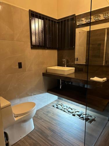 a bathroom with a toilet and a sink at Trébol House in Cuatro Esquinas
