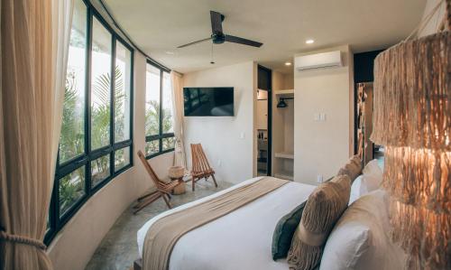 a bedroom with a large bed and large windows at Tulum Jungle Luxury Villa -Pvt Pool - Concierge 6A in Tulum