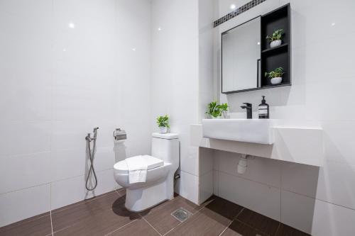 a white bathroom with a toilet and a sink at La Ferringhi Villa - Balinese Collection, by ALV in Batu Ferringhi