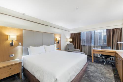 a hotel room with a bed and a desk at Stamford Plaza Adelaide in Adelaide