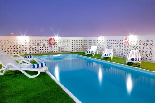 a swimming pool with lounge chairs and a swimming pool at Landmark Hotel in Dubai