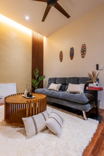 a living room with a blue couch and a table at La Ferringhi Villa - Balinese Collection, by ALV in Batu Ferringhi