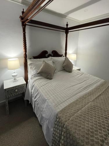 a bedroom with a large bed with a wooden canopy at 3 Br home with kitchen in Beaconsfield