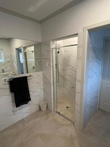 a bathroom with a shower and a glass shower stall at 3 Br home with kitchen in Beaconsfield