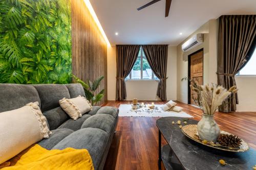 a living room with a couch and a table at La Ferringhi Villa - Balinese Collection, by ALV in Batu Ferringhi