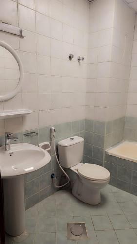 a bathroom with a toilet and a sink at Mangaf Kuwait Family Venus Flat- Beach access in Kuwait