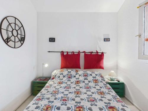 une chambre avec un lit avec des oreillers rouges dans l'établissement Appartement 2 pièces avec terrasse et parking pour 4 personnes - FR-1-326-851, à Marseillan