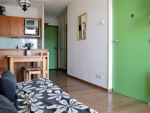 un salon avec une cuisine aux murs verts dans l'établissement Appartement au centre avec parking, 4 couchages - FR-1-593-129, aux Angles