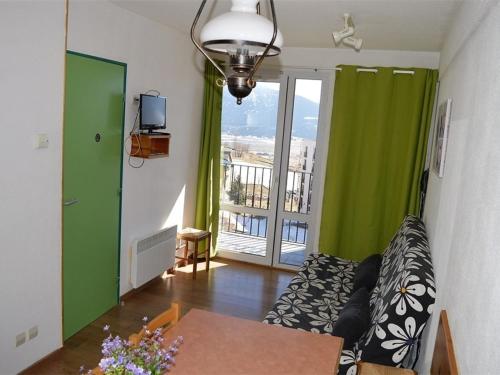 un salon avec un canapé, une table et une fenêtre dans l'établissement Appartement au centre avec parking, 4 couchages - FR-1-593-129, aux Angles