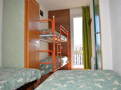 une chambre avec deux lits superposés et une fenêtre dans l'établissement Appartement au centre avec parking, 4 couchages - FR-1-593-129, aux Angles