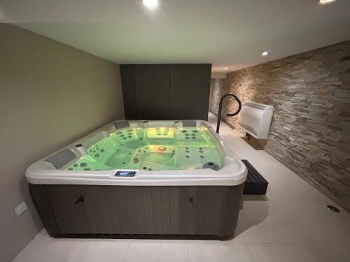 une baignoire jacuzzi dans une chambre avec un mur dans l'établissement Villa d'Exception avec Hammam et Sauna à Saint-Brevin-l’Océan - FR-1-364-179, à Saint-Brévin-les-Pins