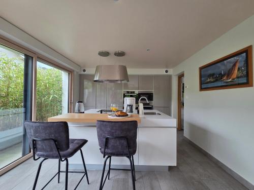 - une cuisine avec 2 chaises et un îlot dans l'établissement Villa d'Exception avec Hammam et Sauna à Saint-Brevin-l’Océan - FR-1-364-179, à Saint-Brévin-les-Pins