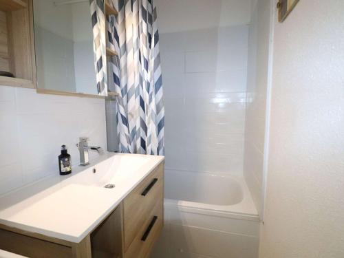 une salle de bain avec un lavabo et une baignoire dans l'établissement Spacieux 3 Pièces Climatisé avec Terrasse et Garage - FR-1-307-281, au Grau-du-Roi