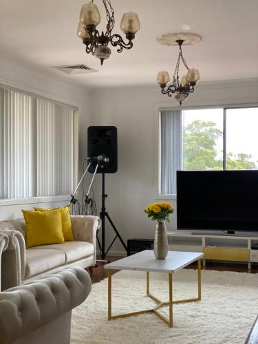 a living room with a couch and a tv at Campbeltown Private Room in Campbelltown South