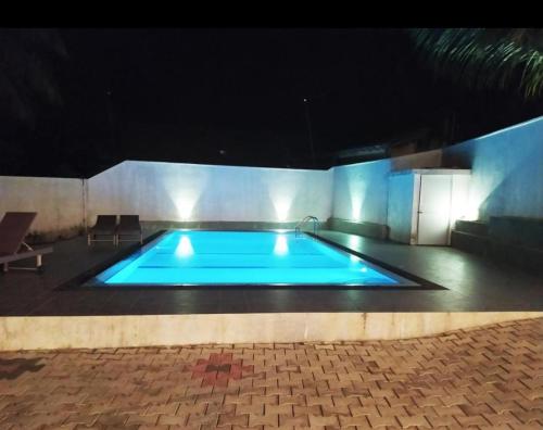 a large swimming pool at night with blue lights at The Green Lagoon Villa in Hikkaduwa