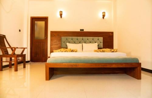 a bedroom with a large bed with a wooden headboard at The Green Lagoon Villa in Hikkaduwa
