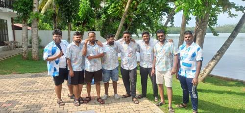 a group of men in hawaiian shirts posing for a picture at The Green Lagoon Villa in Hikkaduwa