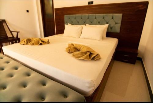 a bed with two brown robes on top of it at The Green Lagoon Villa in Hikkaduwa