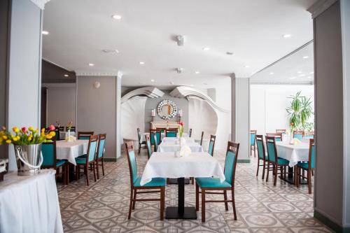 a dining room with white tables and chairs at Hotel Wodnik Twój Hotel z widokiem na morze in Ustronie Morskie