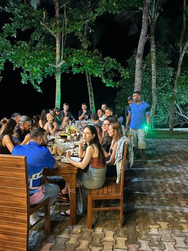 a group of people sitting at a table at night at The Green Lagoon Villa in Hikkaduwa