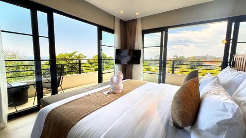 a bedroom with a large bed with large windows at ZIN Canggu Resort & Villas in Canggu