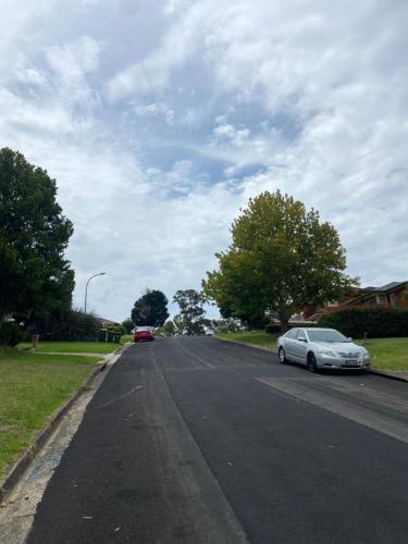 a street with two cars parked on the road at Campbeltown Private Room in Campbelltown South