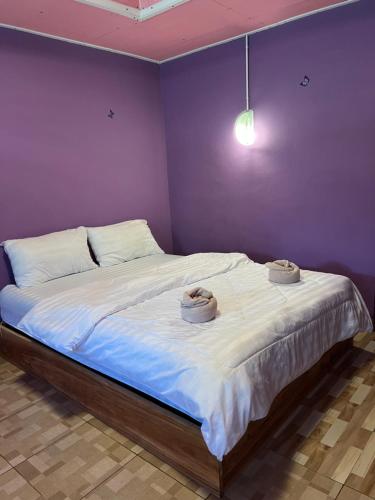 a bedroom with a large bed with two hats on it at ลูกดกแน่โฮมสเตย์ ที่พักเกาะลิบง in Ko Libong