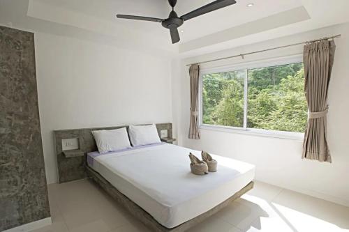 a bedroom with a large bed with a window at Cozy 1br Shared Pool & Sea View In Chaweng in Koh Samui 