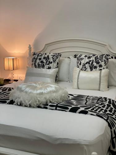 a large white bed with black and white pillows at Campbeltown Private Room in Campbelltown South