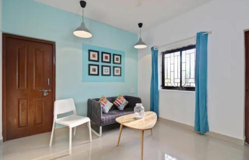 a living room with a couch and a table and chairs at Exotic stay in Nerul