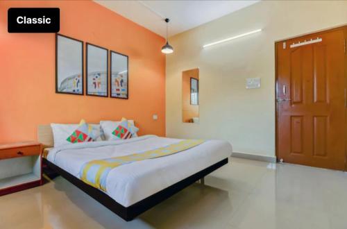 a bedroom with a bed with an orange wall at Exotic stay in Nerul