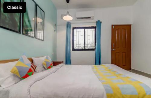 a bedroom with a large white bed with blue curtains at Exotic stay in Nerul