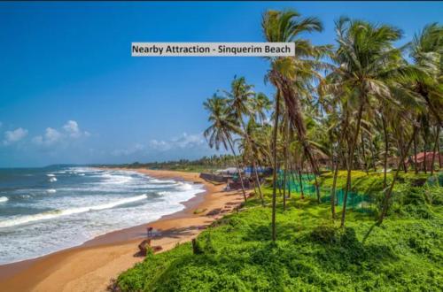 a view of a beach with palm trees and the ocean at Exotic stay in Nerul