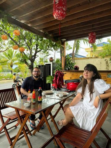 a man and a woman sitting at a table at Seagull Nest Hoi An Beach Village in Tân Thành (1)