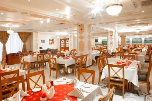 a dining room with white tables and chairs and a restaurant at Landmark Hotel in Dubai