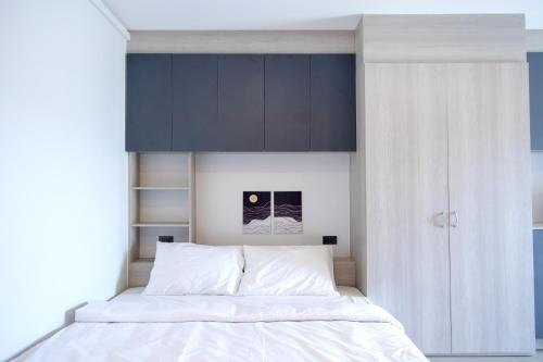 a bedroom with a white bed with a black cabinet at 44 Residence and Resort in Khlong Luang