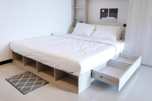 a large bed with a white bed frame and shelves at 44 Residence and Resort in Khlong Luang
