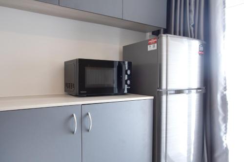 a microwave sitting on top of a counter next to a refrigerator at 44 Residence and Resort in Khlong Luang