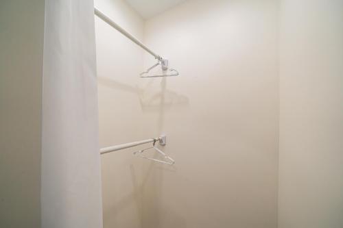 a shower with two hangers and a glass door at Today Aparthotel West Lujiazui Shanghai in Shanghai
