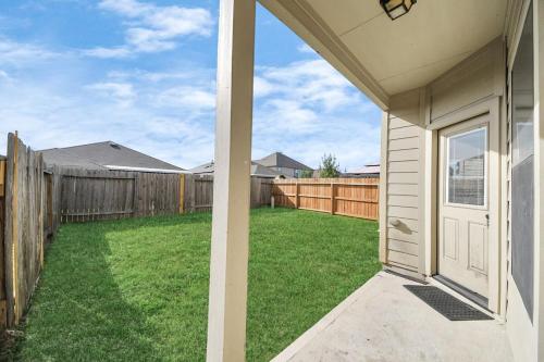 an empty backyard with a fence and a white door at Cozy & Spacious Getaway -4Bedroom With King bed & Backyard in Houston