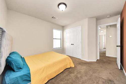 a bedroom with a bed with a yellow blanket at Cozy & Spacious Getaway -4Bedroom With King bed & Backyard in Houston
