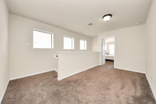 an empty living room with white walls and windows at Cozy & Spacious Getaway -4Bedroom With King bed & Backyard in Houston