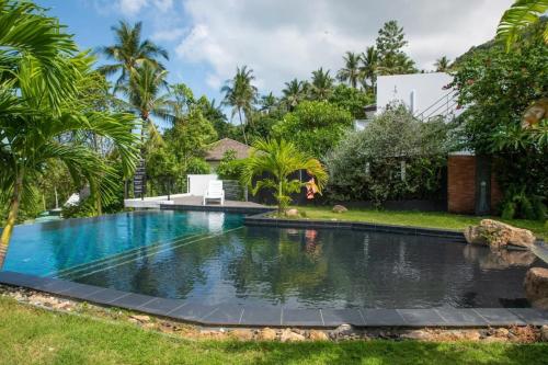 a swimming pool in the yard of a house with palm trees at Duplex 2br Pool & Seaview - Chaweng in Chaweng