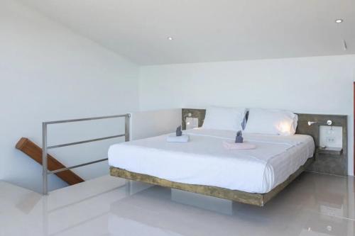 a bedroom with a white bed with a metal frame at Duplex 2br Pool & Seaview - Chaweng in Chaweng