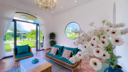 a living room with two chairs and a large vase of flowers at Nhà Vườn NGô Tất Tố , lộc châu , TP bảo lộc in Ðại Lào