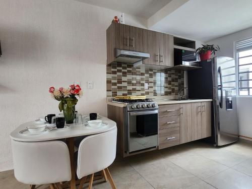 a kitchen with a table with a vase of flowers on it at Residencial Eduardo Molina in Mexico City