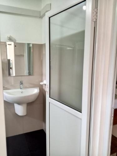 a bathroom with a sink and a glass shower door at 682 Villa Weligama in Weligama