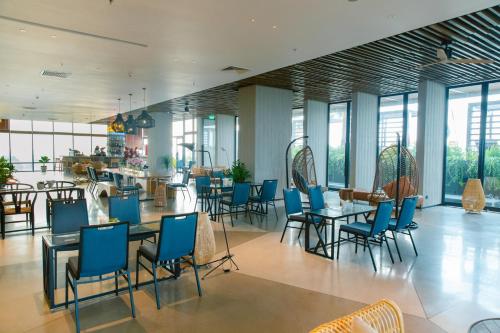 a restaurant with blue chairs and tables and windows at CENTRAL PLAZA HOTEL - Mỹ Tho in My Tho