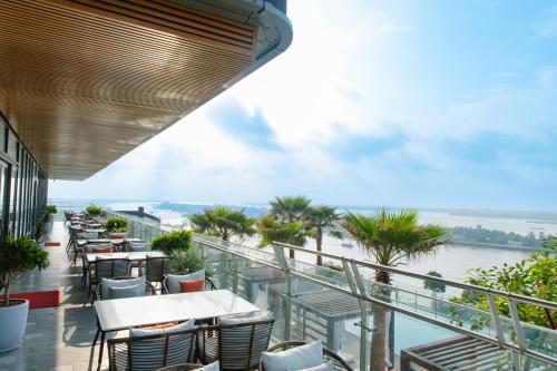 a balcony with tables and chairs and a view of the water at CENTRAL PLAZA HOTEL - Mỹ Tho in My Tho