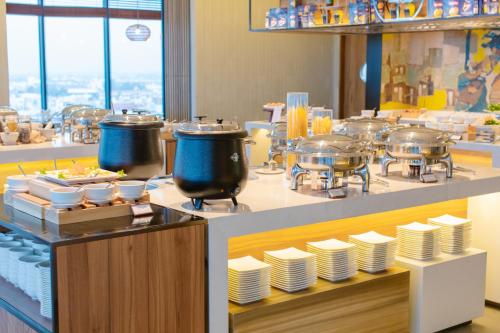 a buffet line with dishes and pots and pans at CENTRAL PLAZA HOTEL - Mỹ Tho in My Tho